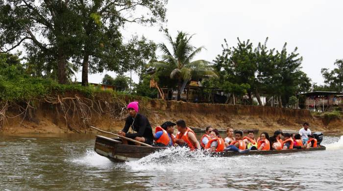 Fotografía del 8 de octubre de 2024 de migrantes transportándose en una lancha por el rio Turquesa desde el pueblo de Bajo Chiquito al centro de recepción migratoria de Lajas Blancas.