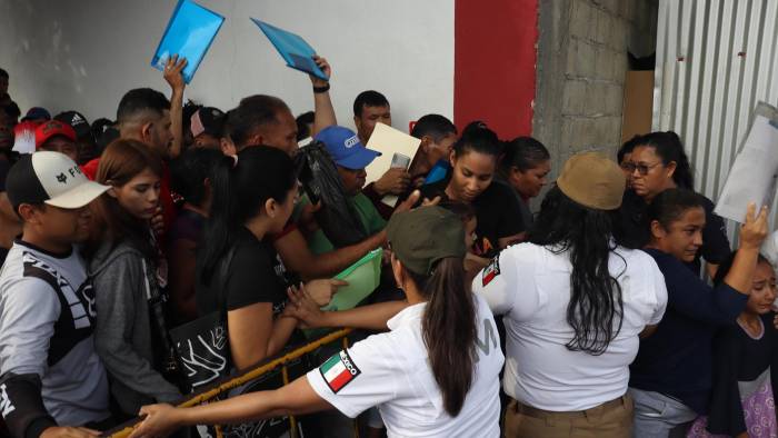 Migrantes hacen fila para tramitar papeles migratorios este viernes, en el municipio de Tapachula en Chiapas.