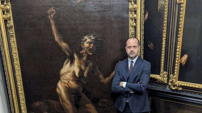 El director de la Galería de los Uffizi, Simone Verde, posa junto a la obra 'La Bruja', considerada la obra maestra de la pintura esotérica del siglo XVII, del artista maldito Salvator Rosa.