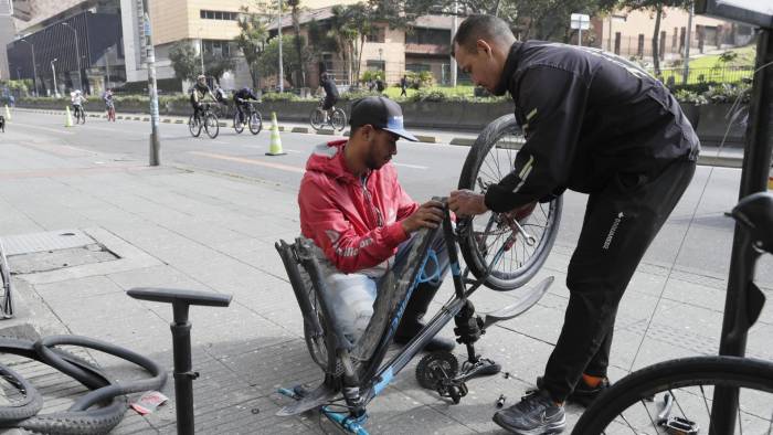 Un mecánico arregla una bicicleta en la ciclovía domingo, en Bogotá.