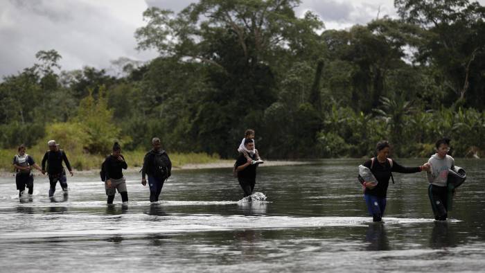 Fotografía de archivo en donde se ven migrantes que cruzan el río Tuquesa luego de atravesar la selva del Darién, frontera natural entre Colombia y Panamá.