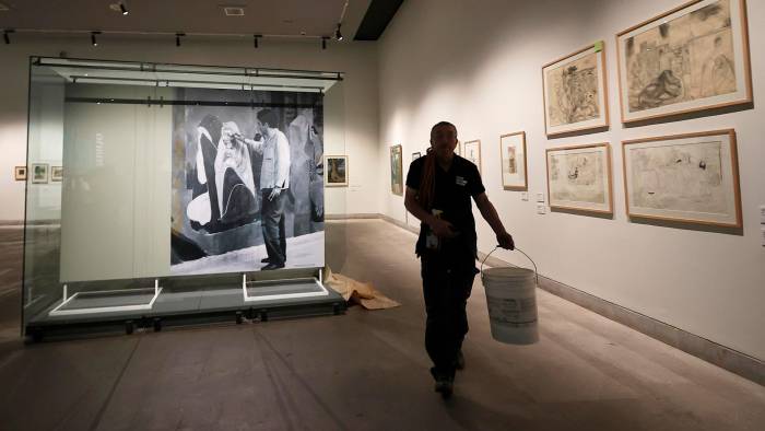 Un hombre trabaja en el montaje de la exhibición 'Centenario José Venturelli. Humanismo y compromiso social'.