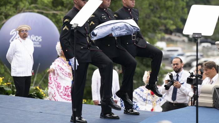 Cadetes marchan con la bandera de Panamá en la ceremonia conmemorativa por los 25 años de la transferencia del Canal de Panamá este martes, en el edificio de la Administración del Canal en la Ciudad de Panamá (Panamá).