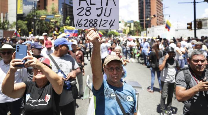 Fotografía de archivo de un seguidor de la líder opositora venezolana María Corina Machado, que sostiene un cartel en una manifestación en Caracas.