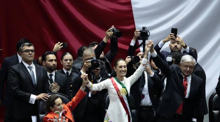 La presidenta de México Claudia Sheinbaum (centro) acompañada del mandatario saliente, Andrés Manuel López Obrador (2018-2024), saludan al termino de la toma de posesión en la Cámara de Diputados este martes en la Ciudad de México.