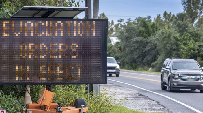 Un vehículo avanza junto a una señal de 'evacuación obligatoria y advertencia de huracán', mientras la localidad se prepara para el huracán Helene, en Cedar Key, Florida, EE.UU., el 25 de agosto de 2024.