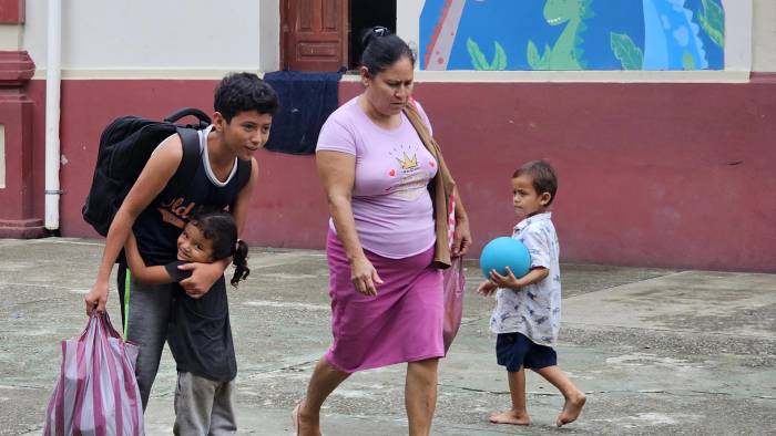 Habitantes de los campos bananeros caminan con sus pertenencias, este domingo en El Progreso Yoro (Honduras).