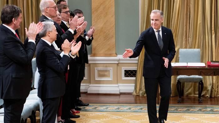 El primer ministro canadiense, Mark Carney (d), nuevo líder del Partido Liberal, saluda a su ministro de gabinete tras ser juramentado como primer ministro de Canadá en el Rideau Hall de Ottawa, Canadá.