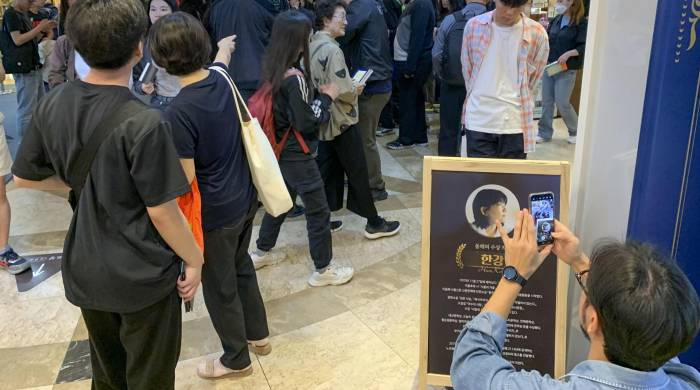 Clientes en la librería principal de la cadena Kyobo, en el distrito de Jongno en Seúl, se agolpan para adquirir libros de la escritora Han Kang un día después de que fuera galardonada con el premio Nobel de Literatura.