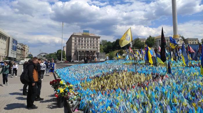 Un grupo de ucranianos rinde homenaje a los caídos en la guerra en el mar de banderas que recuerda a los soldados ucranianos y extranjeros muertos en combate en la guerra con Rusia, el pasado 16 de mayo en Kiev (Ucrania).
