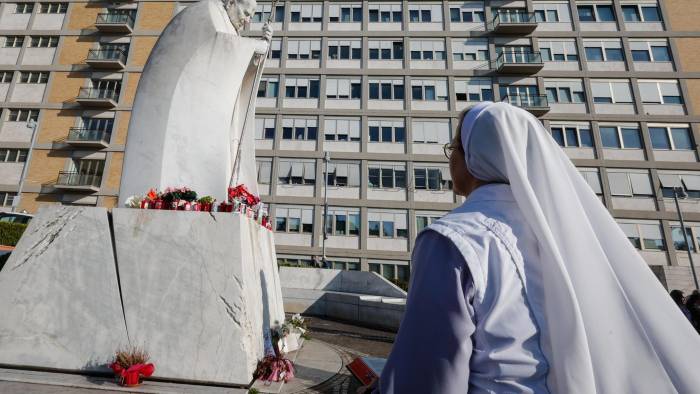 Una monja reza ante una estatua del Papa San Juan Pablo II fuera del Hospital Universitario Gemelli, donde el papa Francisco.