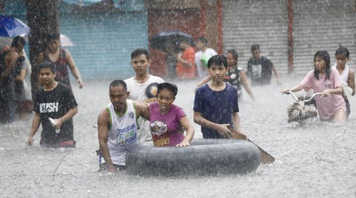 Residentes andan este miércoles entre las inundaciones en Marikina, en la metrópoli de Manila, donde las autoridades han declarado el estado de calamidad.