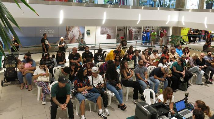 Decenas de personas esperan en una sala para inscribirse en el registro de votantes en San Juan.